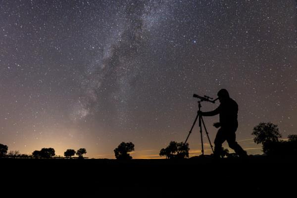 Man using telescope to see night sky 