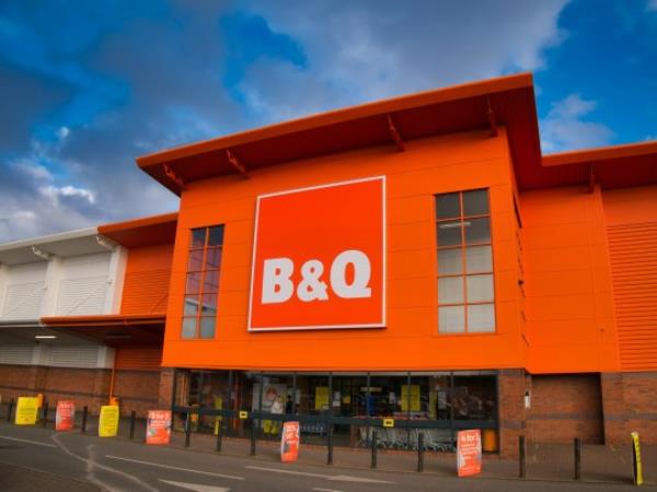 The fro<em></em>ntage and brand logo of a branch of the UK DIY store B&Q, taken in a local retail park on Wirral, UK on a sunny afternoon