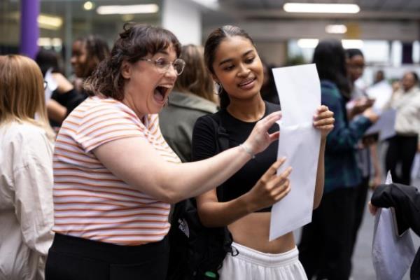 LONDON, UNITED KINGDOM - AUGUST 18: Student Maya Adams (R) of The City of Lo<em></em>ndon Academy in Southwark opens her A-Level results with her drama teacher Ms Young on August 18, 2022 in London, United Kingdom. This is the first year since 2019 that A-level results are ba<em></em>sed on public exams, after pandemic-related disruptions in 2020 and 2021 led to A-level results relying on teachers' assessments. A-level grades are expected to be lower this year on average. (Photo by Dan Kitwood/Getty Images)