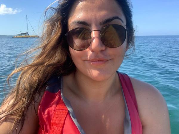 Almara on a boat, wearing a life jacket and sunglasses, smiling