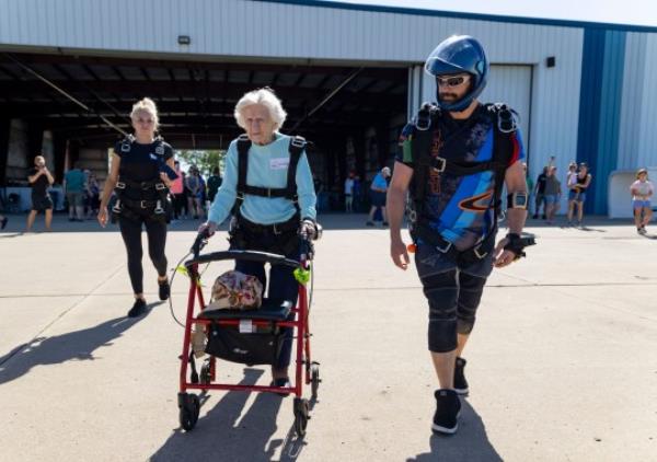 Dorothy Hoffner walks out to the plane with tandem jumper Derek Baxter 