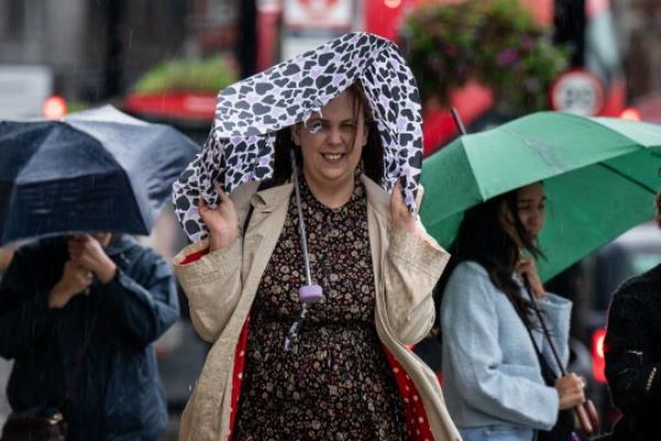 People walk through the rain and wet weather in Victoria, London. Picture date: Wednesday September 20, 2023. PA Photo. See PA story WEATHER Autumn. Photo credit should read: Aaron Chown/PA Wire