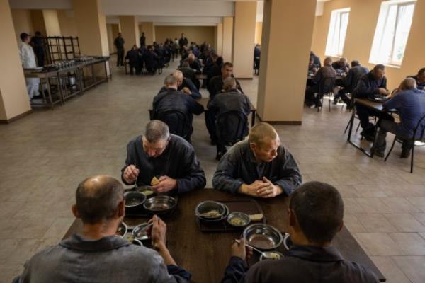 LVIV REGION, UKRAINE - AUGUST 3: Priso<em></em>ners eat lunch in the cafeteria inside the Russian priso<em></em>ner of war detention camp in the Lviv region, western Ukraine on August 3, 2023. Hundreds of captured Russian POWs including cons<em></em>cripts, mercenaries, Wagner militia and Storm-Z Russian priso<em></em>ners are being held in up to 50 sites around Ukraine. Storm-Z is a series of penal military units established by Russia since April 2023. (Photo by Paula Bro<em></em>nstein /Getty Images