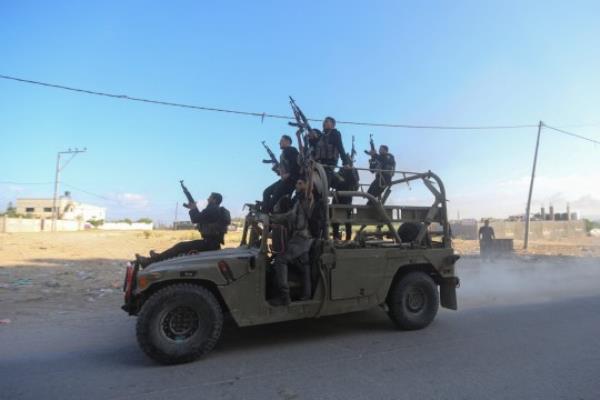 Palestinian militants ride an Israeli military vehicle that was seized by gunmen who infiltrated areas of southern Israel, in the northern Gaza Strip October 7, 2023. REUTERS/Ahmed Zakot