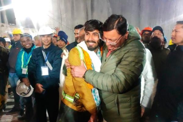 This handout photo provided by the Uttarakhand State Department of Information and Public Relations shows Pushkar Singh Dhami, right, Chief Minister of the state of Uttarakhand, greeting a worker rescued from the site of an under-co<em></em>nstruction road tunnel that collapsed in Silkyara in the northern Indian state of Uttarakhand, India, Tuesday, Nov. 28, 2023. Dhami said eight workers were rescued so far on Tuesday. The laborers are being pulled out through a passageway made of welded pipes which rescuers previously pushed through dirt and rocks. (Uttarakhand State Department of Information and Public Relations via AP)